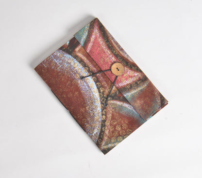 Handmade abstract painted diary with multicolored geometric patterns in shades of red, blue, and gold, featuring a wooden button closure on a textured fabric cover