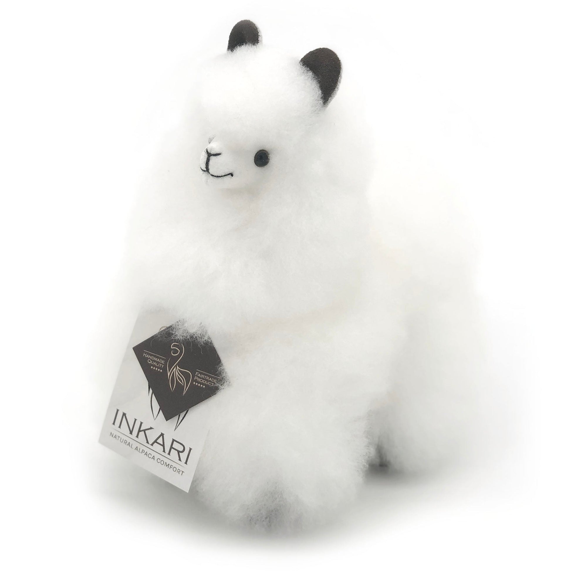 Adorable ivory white alpaca stuffed animal, handmade from natural wool. Fluffy and soft texture, featuring cute black ears and eyes. INKARI brand tag attached, showcasing eco-friendly and fair trade production.