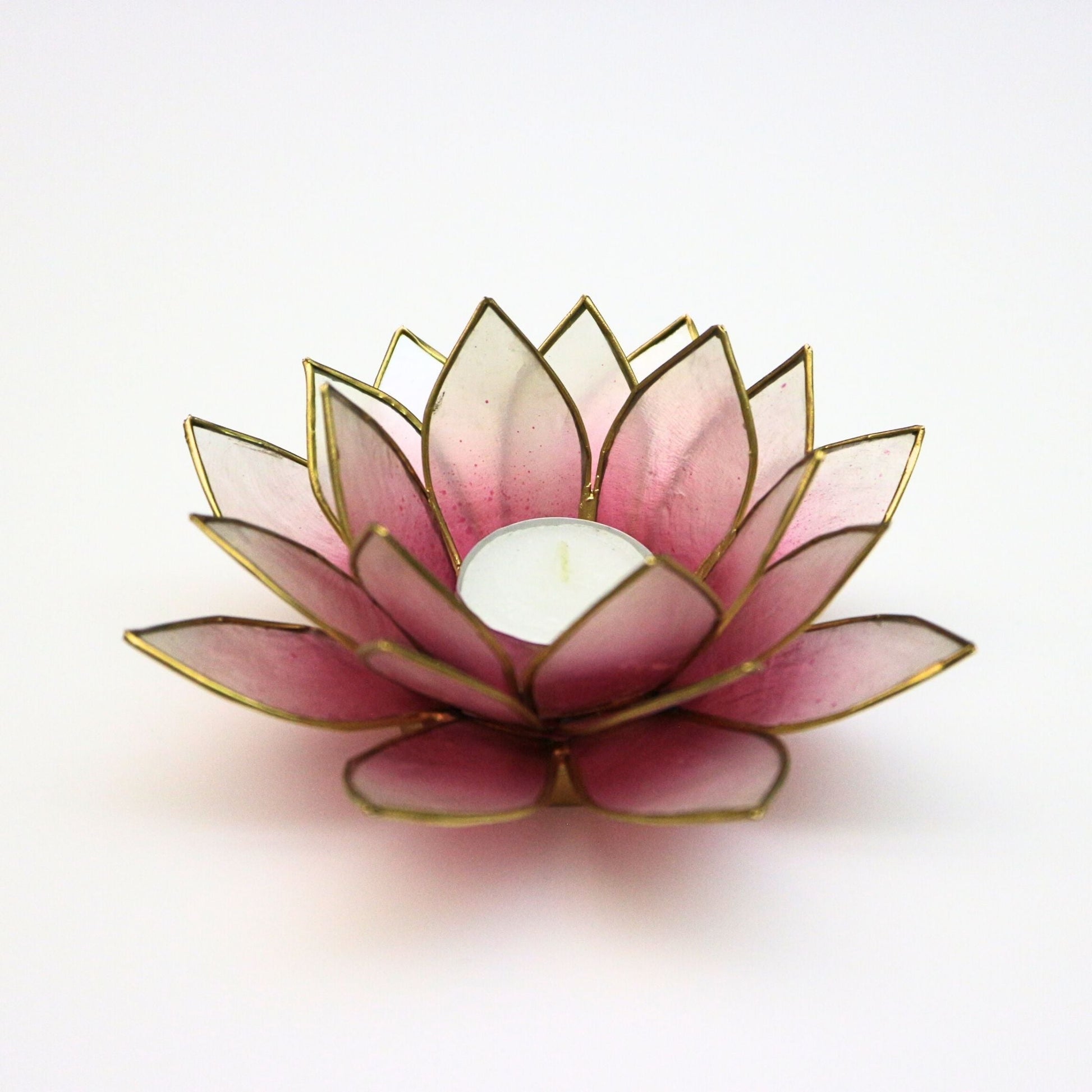 Handcrafted lotus-shaped capiz shell tealight holder in pink and natural white with gold trim, showcasing delicate petals and a central space for a candle