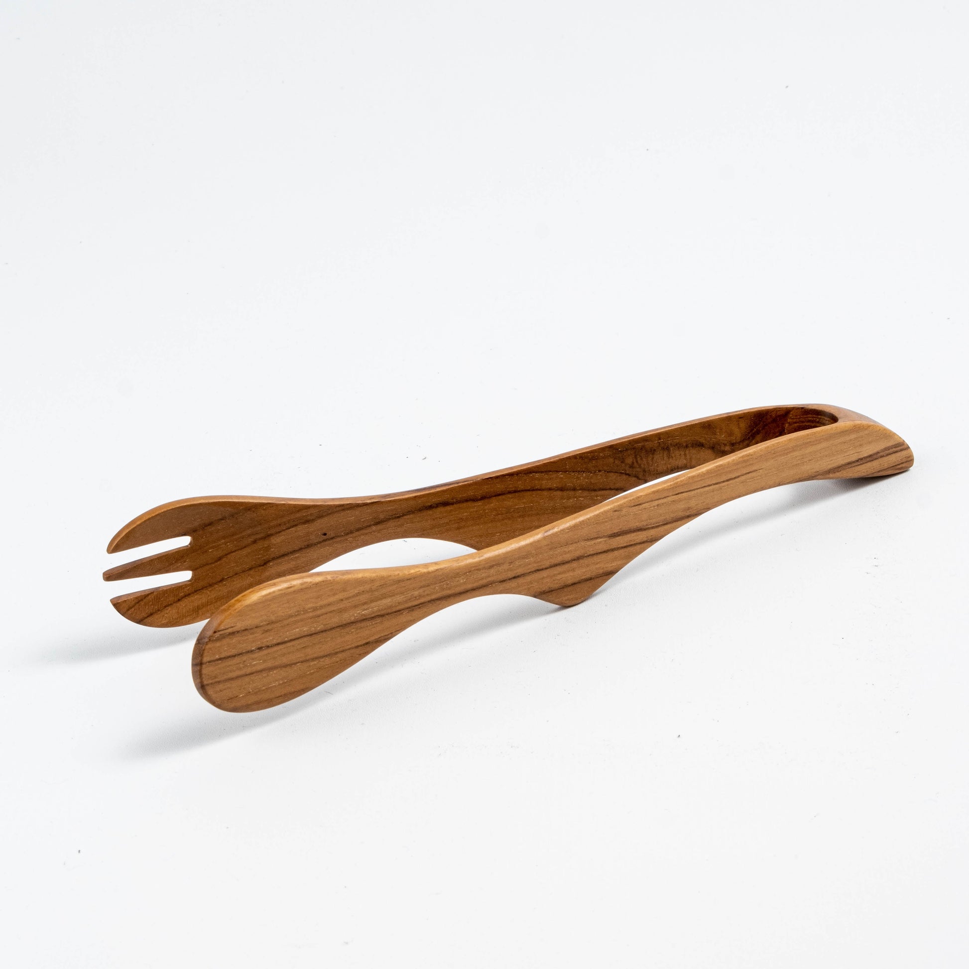 Elegant teak wood salad picker set with fork and spoon utensils, showcasing natural wood grain and smooth curved design, handcrafted by Indonesian artisans for sustainable dining experience