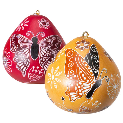 Handcrafted Peruvian gourd ornaments with intricate butterfly doodle designs in vibrant red and yellow, showcasing traditional carving and burning techniques, perfect for eco-friendly and fair trade decor