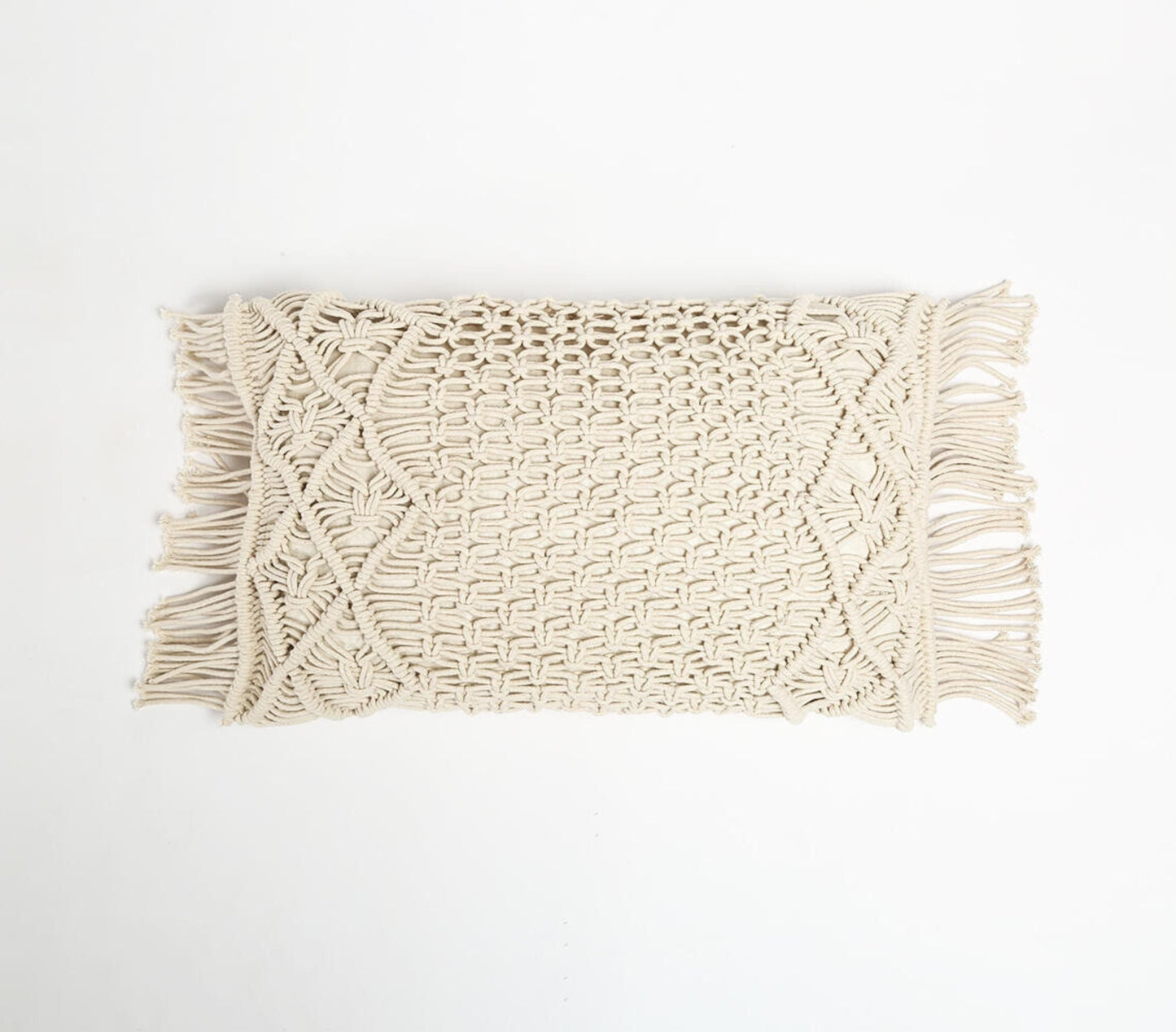 Handmade macrame cushion cover in natural white with intricate diamond weave pattern, fringed sides, and varying knot sizes. Rectangular shape showcasing traditional artisan craftsmanship and modern bohemian style.