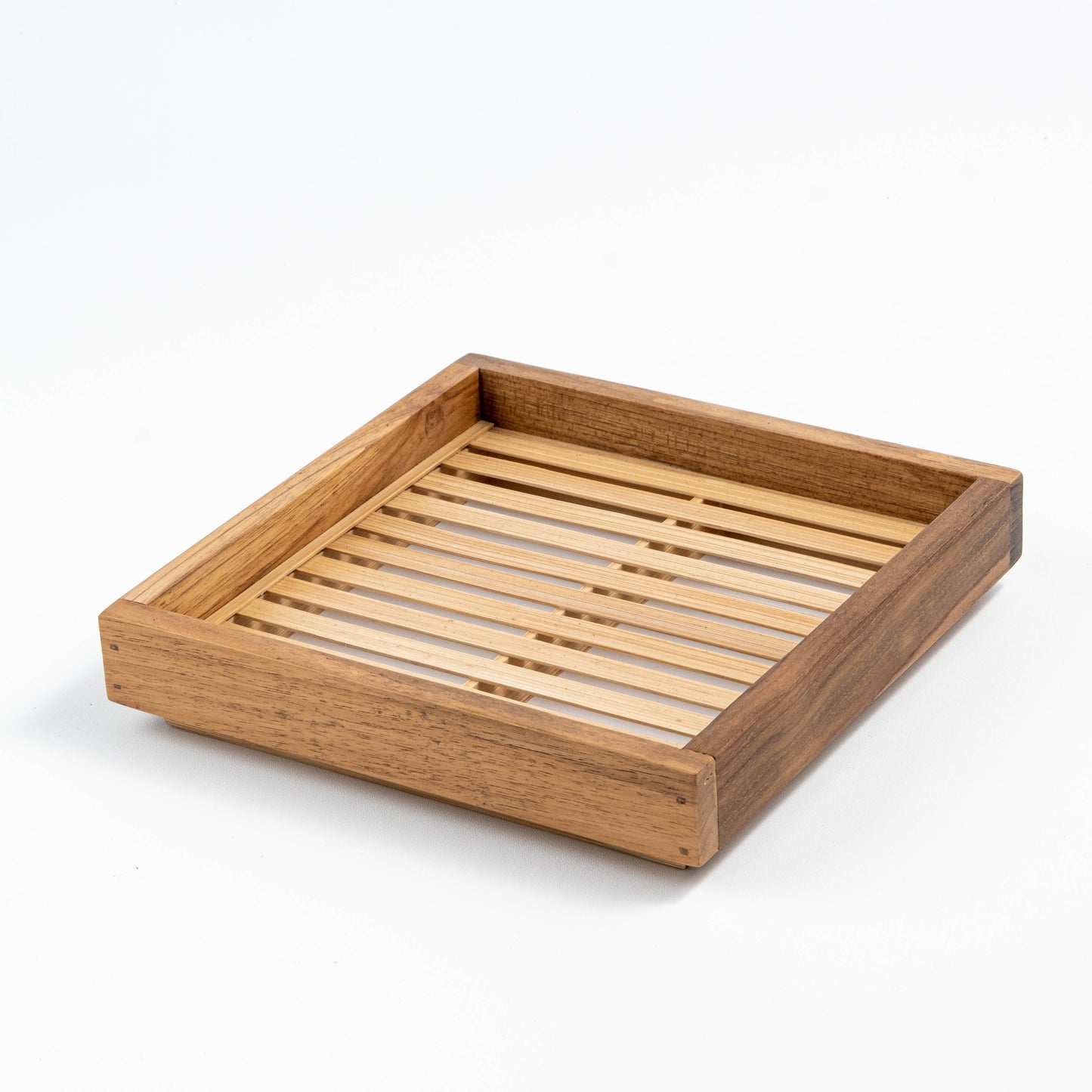 Handcrafted square teak and bamboo tray with slatted design, showcasing natural wood grain and sustainable materials. Versatile for serving, display, or dining table centerpiece.